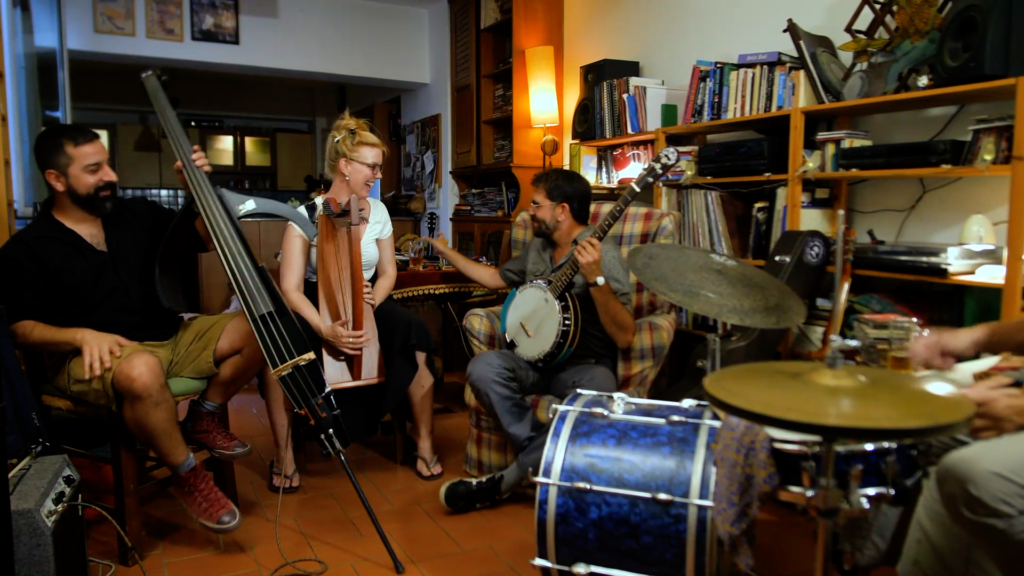 A group of musicians in a living room making music together