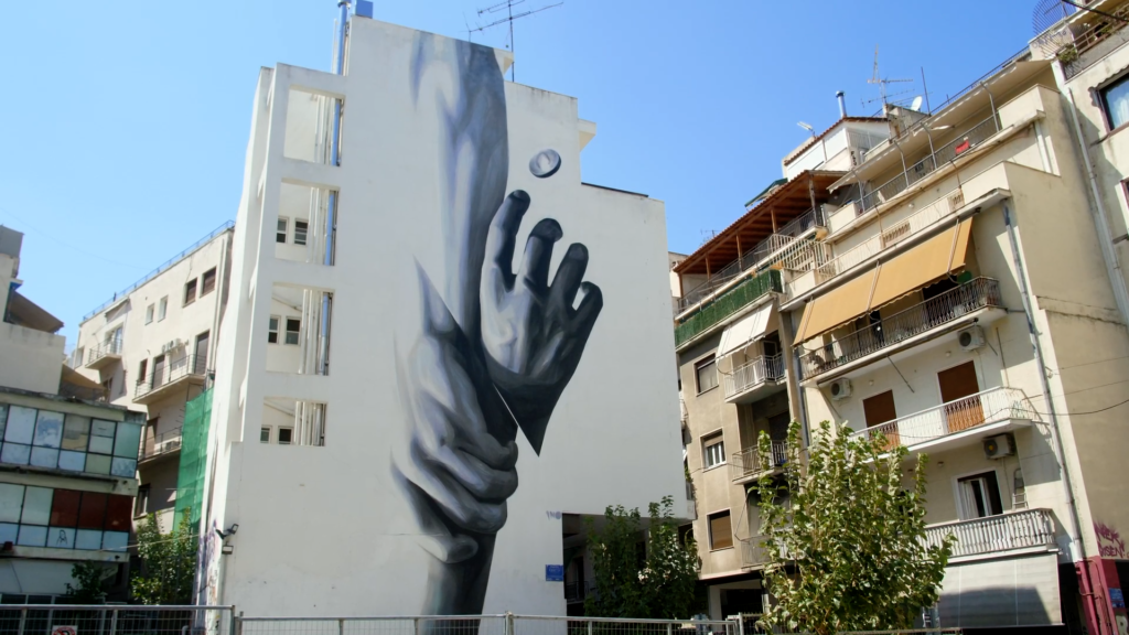 A mural of two hands holding each other in Greece.